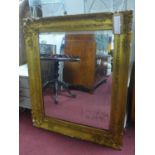 A late 19th / early 20th century giltwood mirror, with floral decoration, chips to frame, 92 x 79cm