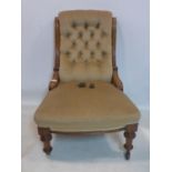 A Victorian mahogany chair with velour button back upholstery, raised on turned legs and castors