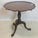 A Georgian mahogany tilt top table, with pie crust top, raised on carved supports and cabriole legs,