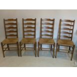 A set of four oak ladder back dining chairs with rush seats