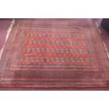 A large 20th century Bokhara carpet with repeating gull motifs, on a red ground, contained by many