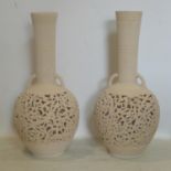 A pair of Persian vases, with pierced floral decoration, having twin handles and elongated necks,