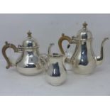 A three piece silver tea set, to include teapot, hot water pot with wooden handles and finials,