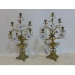 A pair of Continental gilt metal five branch six light candelabras, of urn and flower design with