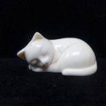 A late 19th century Japanese ivory netsuke modelled as a sleeping cat, signed to base, approx. H.3