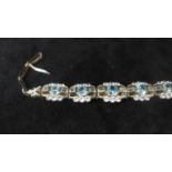 An Art Deco blue Zircon, white Sapphire in-line bracelet, silver fronted, backed in gold.