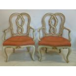 A pair of early 19th Italian cream and gilt painted armchairs, with carved knotted back rests,