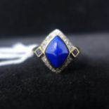 A diamond shaped lapis lazuli ring, set with diamonds and square cut sapphire, on a 9ct yellow