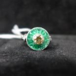 A platinum emerald and brilliant-cut diamond target ring, the central round diamond of 0.50 carats