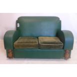 An Art Deco sofa with green vinyl upholstery, raised on castors