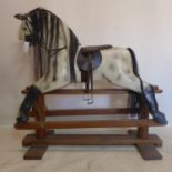 A large 20th century hand-painted rocking horse with horse hair detailing and leather stirrups and