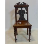 A 19th century mahogany hall chair, with pierced back with scrolling decoration, on turned legs