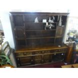 An 18th century oak dresser base with 5 drawers and 2 cupboard doors, raised on block feet, with
