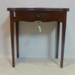 An Edwardian mahogany card table, with fold-over top having green baize, raised on tapered legs