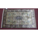 A 20th century silk Tabriz rug with floral medallion, on a beige ground, contained by blue floral