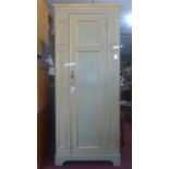 A pale green and gilt painted wardrobe, with moulded cornice above single door, raised on bracket