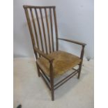 A late 19th / early 20th century ladder back chair with rush seat, raised on tapering legs joined by