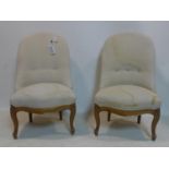 A pair of late 19th century French walnut chairs, with button back stone linen upholstery, raised on