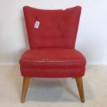 A mid 20th century bedroom chair with buttoned upholstery, raised on beech wood legs
