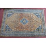 An antique Qashqai carpet with geometric medallion surrounded by geometric motifs, on a brown