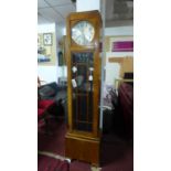 An Art Deco longcase clock, the silvered dial with Arabic numerals, astragal glazed door, on