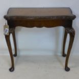 An Irish walnut fold over card table, with carved shell legs