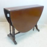 A Regency style mahogany drop leaf table, raised on turned legs and castors