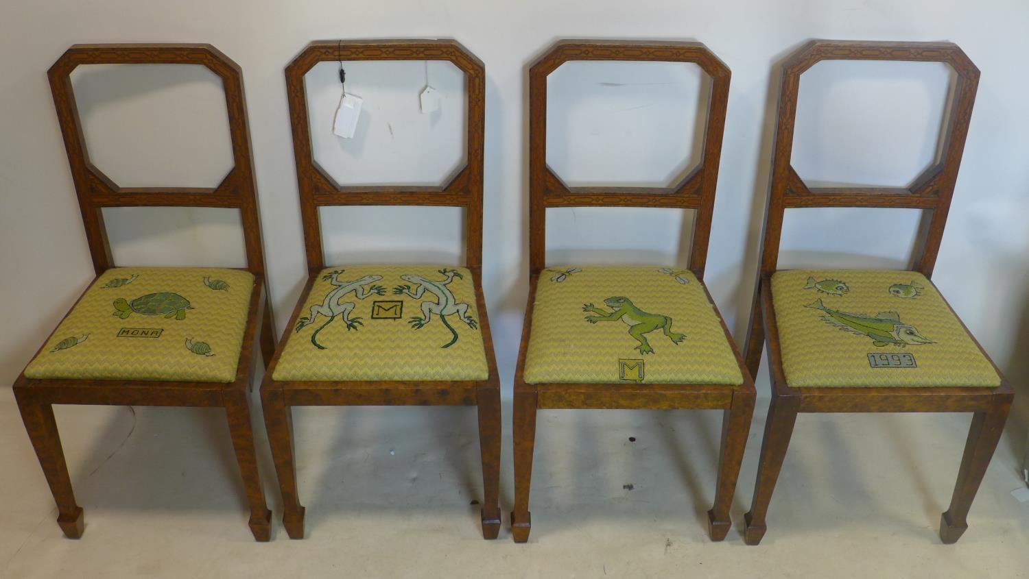 A set of four Art Deco burr walnut dining chairs, with inlaid square framed back rests, raised on