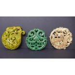 Three, Chinese hand-carved hard-stone amulets/pendants in shades of dark green 6.5 x 6.5cm, white