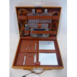 A vintage travelling vanity case, with glass bottles, containers, mirror, brushes and nail tools