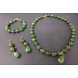 A suite of rare polished green zoisite beads with ruby inclusions to include a necklace L. 48cm,