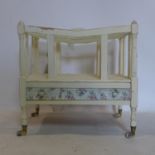 A 20th century white painted Canterbury, with one floral decorated long drawer, raised on turned