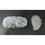 A Chinese polished and hand-carved jadeite paperweight in hues of pale green adorned with 2