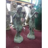 Two cast iron fairies in the verdigris finish, one holding a leaf, the other holding a bird,