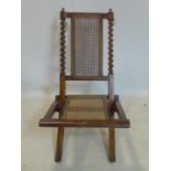 A late 19th century mahogany folding campaign chair, with cane seat and back rest, having barley