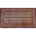 A North-East Persian Turkoman rug, repeating stylised Tekkeh motifs on an ivory field complimented