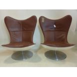 A pair of 20th century fibreglass chairs with brown leather upholstery