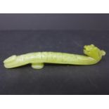 A Chinese, hand-carved yellow/green jade rest in the form of a mythical beast, H. 2cm, L. 10cm