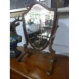 An Edwardian mahogany shield shape vanity mirror, with bevelled plate