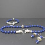 A lapis lazuli and white metal suite to include polished bead necklace and bracelet both with
