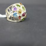 A sterling silver wire-work gem-set ring set with green and red garnets, peridot, sapphire, blue