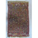 An early 20th century woollen rug with allover chevron motif in shades of red, yellow and beige,
