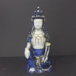 A Chinese glazed pottery figure of a seated Guanyin wearing an ornate headress, 28 x 14cm
