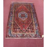 A North-West Persian Zanjan rug, central diamond medallion with repeating petal motifs on a rouge
