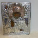 A Russian icon of St Nicholas of Myra, partial painted wood panel, with silver and brass oklad,
