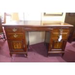 An Edwardian marquetry inlaid mahogany knee hole desk, raised on castors, H.79 W.128 D.57cm