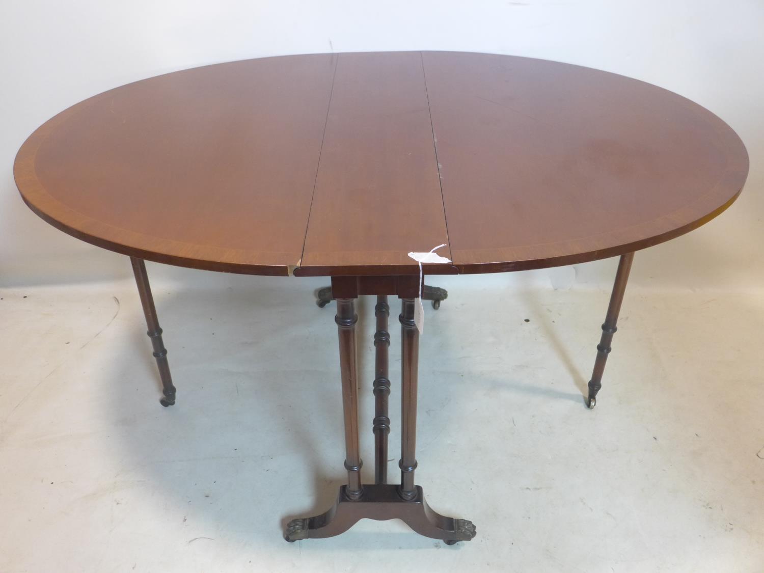 A Regency style mahogany drop leaf table, raised on turned legs and castors - Image 2 of 2