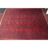 A large 20th century Bokhara carpet with repeating gull motifs, on a red and black ground, contained