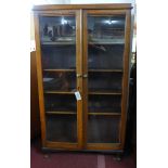 An early 20th century large oak bookcase, with 2 glazed doors, raised on cabriole feet, H.178 W.92