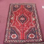A South-West Persian Lori rug, central dimaond medallion with repeating petal motifs on a rouge